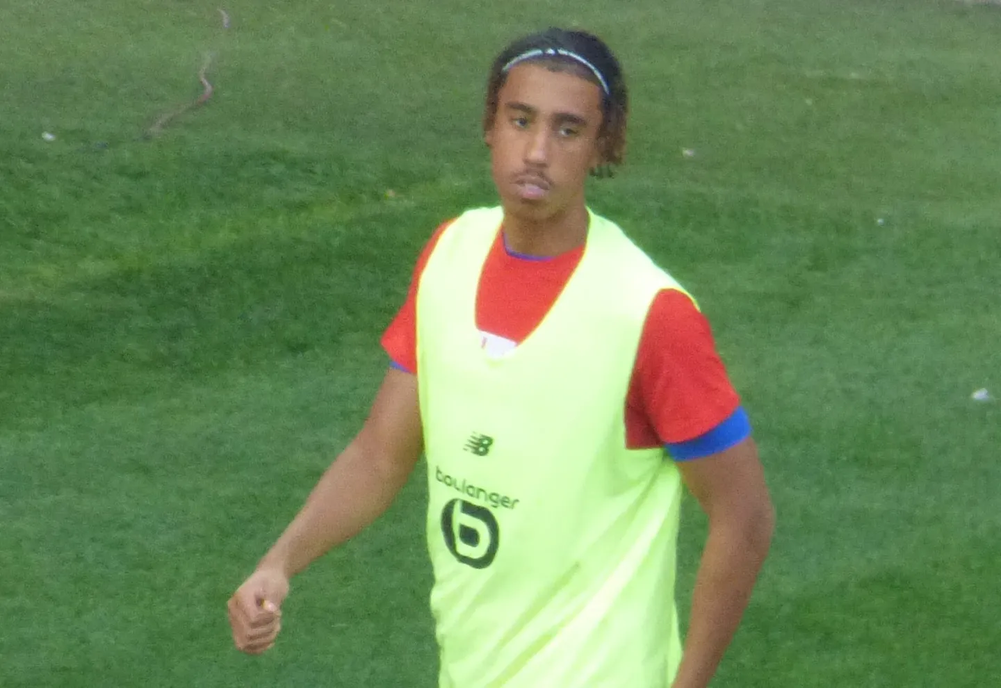 ليني يورو يرتدي صدرية تدريب صفراء فوق قميص أحمر على أرض الملعب.