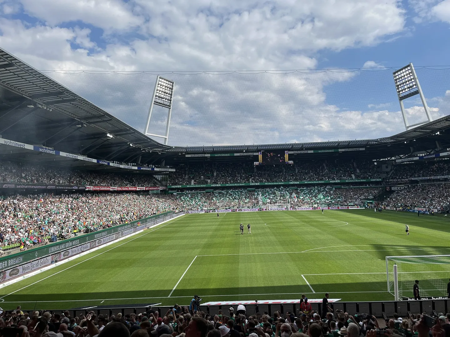 A packed Weserstadion in Bremen, with green-clad supporters in the stands and players on the pitch before kick-off.